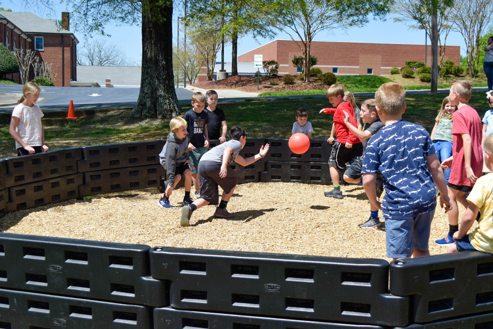 kids playing GaGa ball outside on a playground