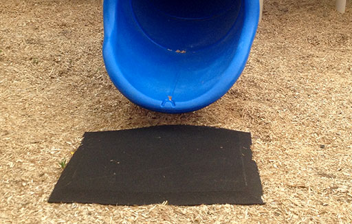 wear mat under a slide on a playground